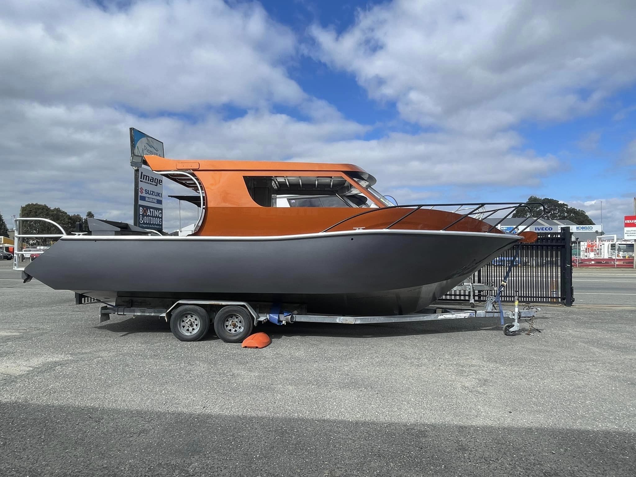 Image Boats NZ 8.0 Fishfinder Orange Boat parked in front of shop